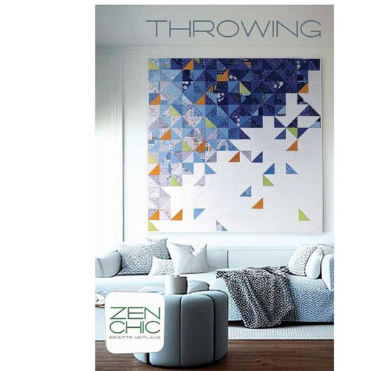 Living room with a geometric patterned quilt on the wall, featuring the brand 'Zen Chic'.