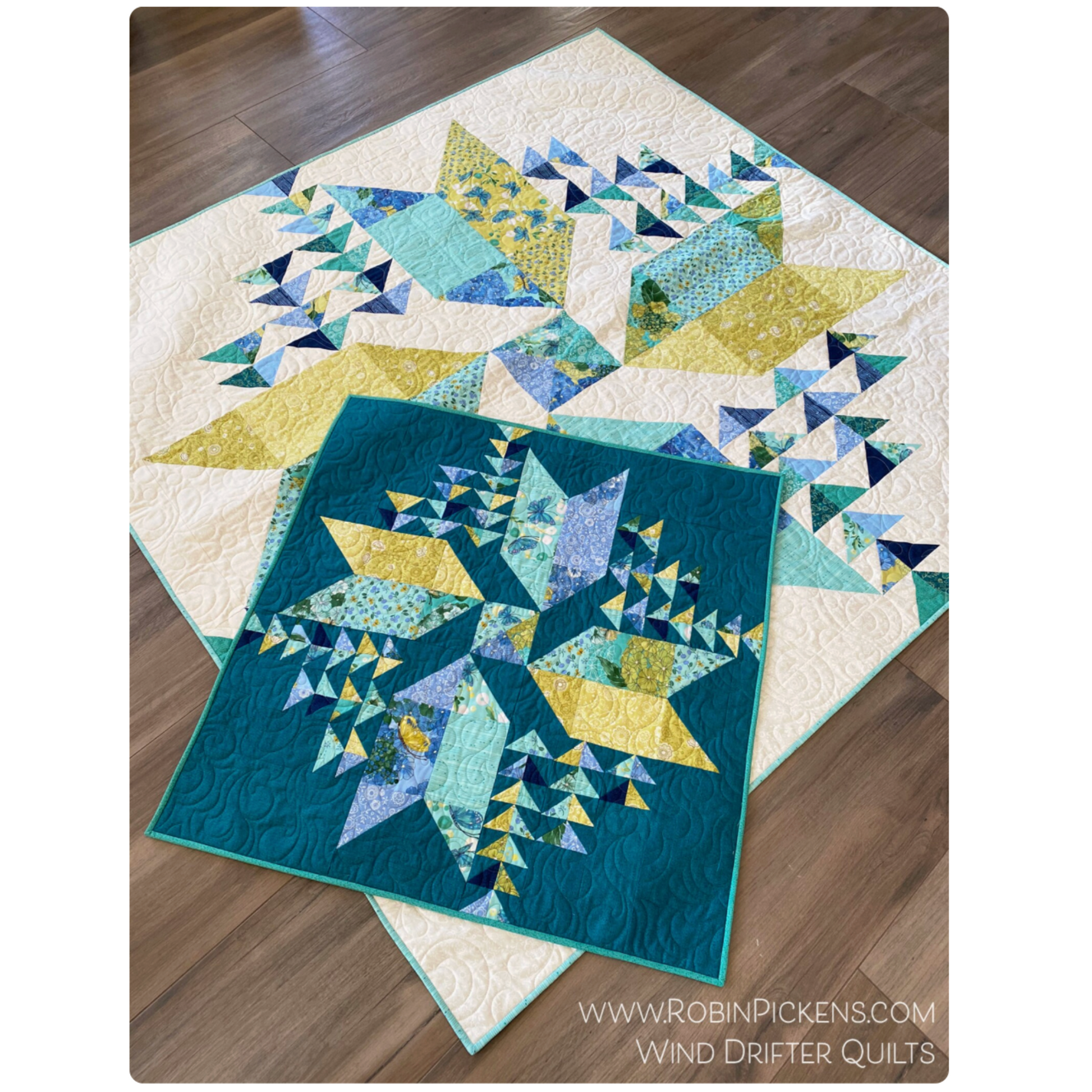 Quilt with geometric pattern on a wooden floor, featuring colors like blue, green, and yellow.