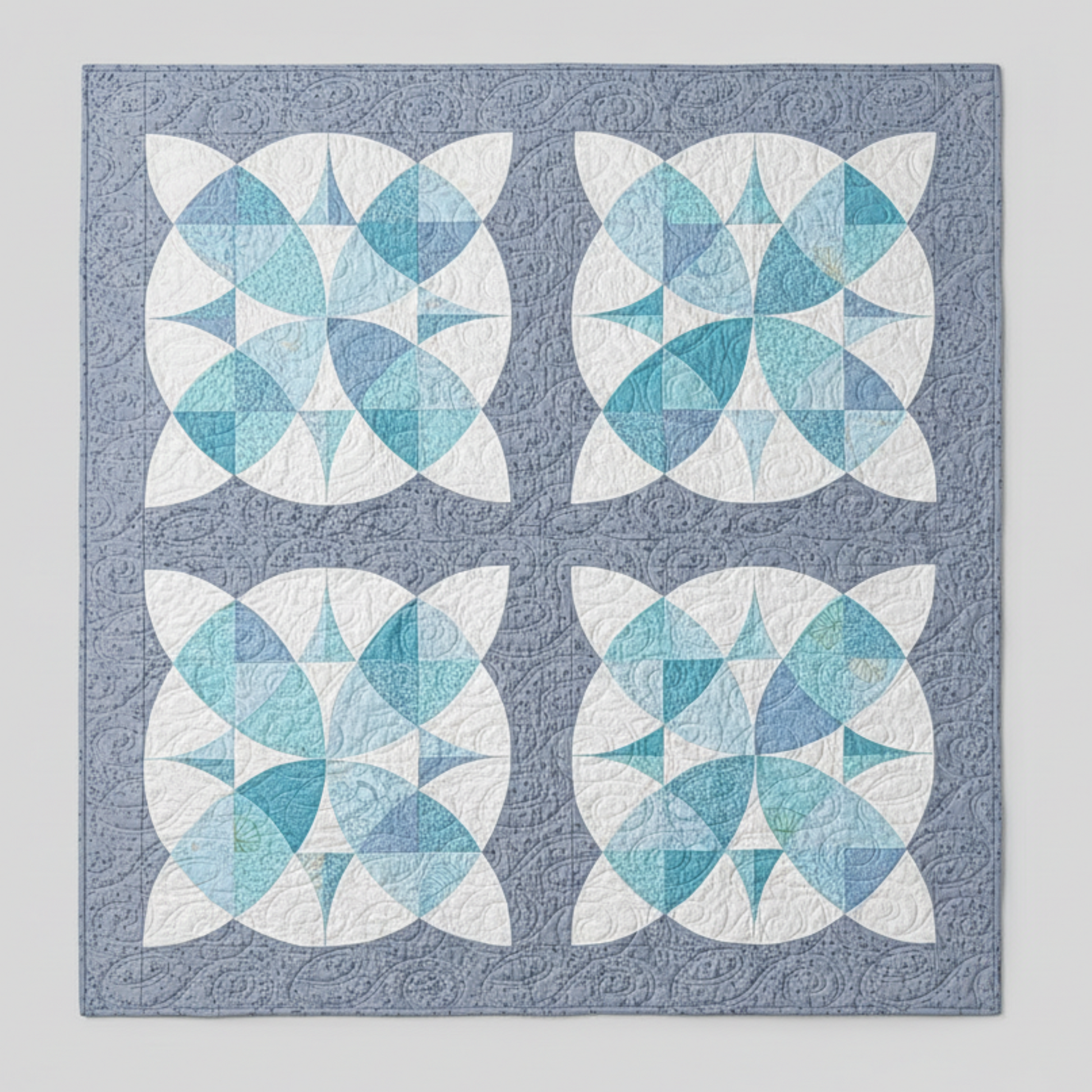 Quilt with blue and white geometric pattern on a gray background