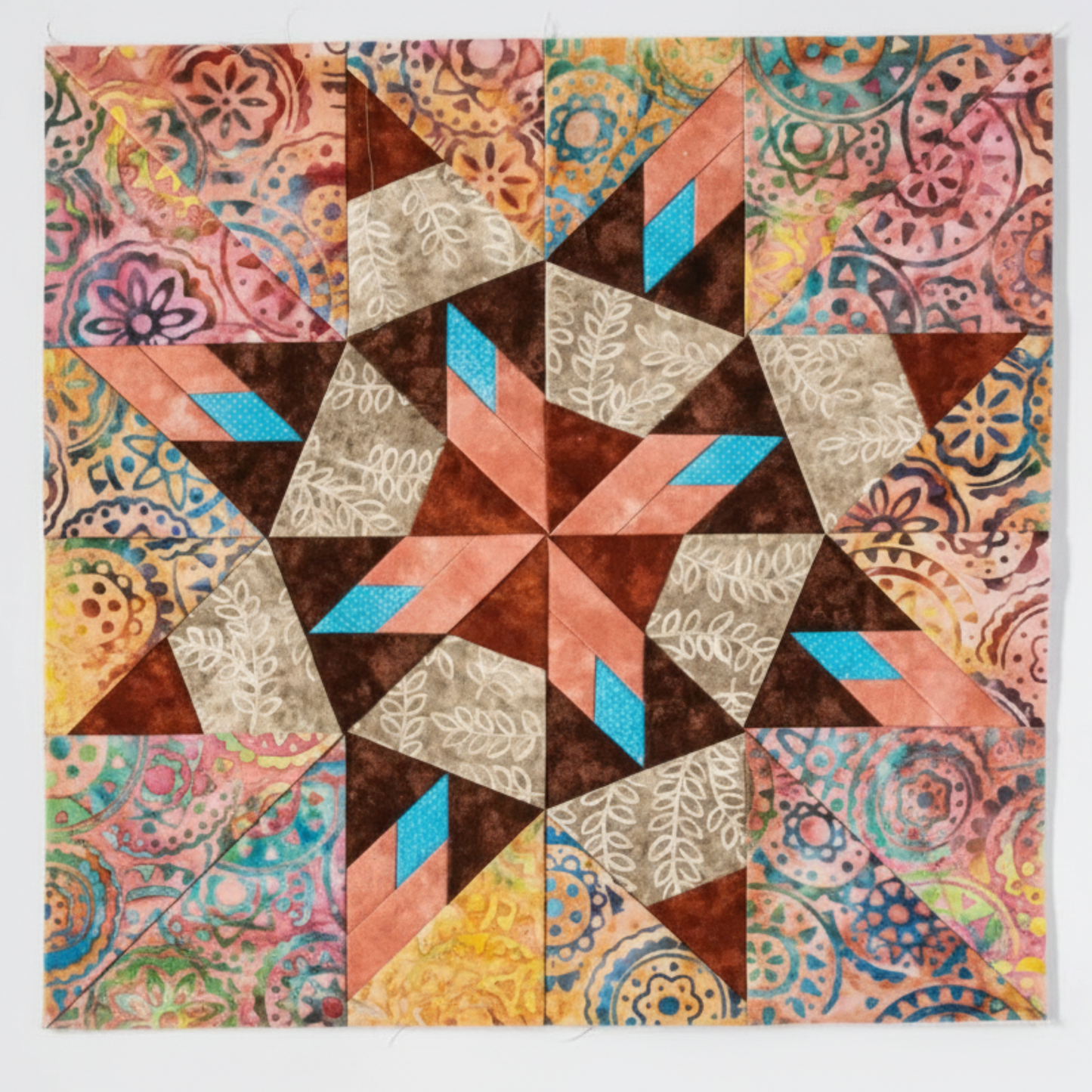 “Paper-pieced star quilt block using multicolor batik fabrics from Carol Doak quilting book”