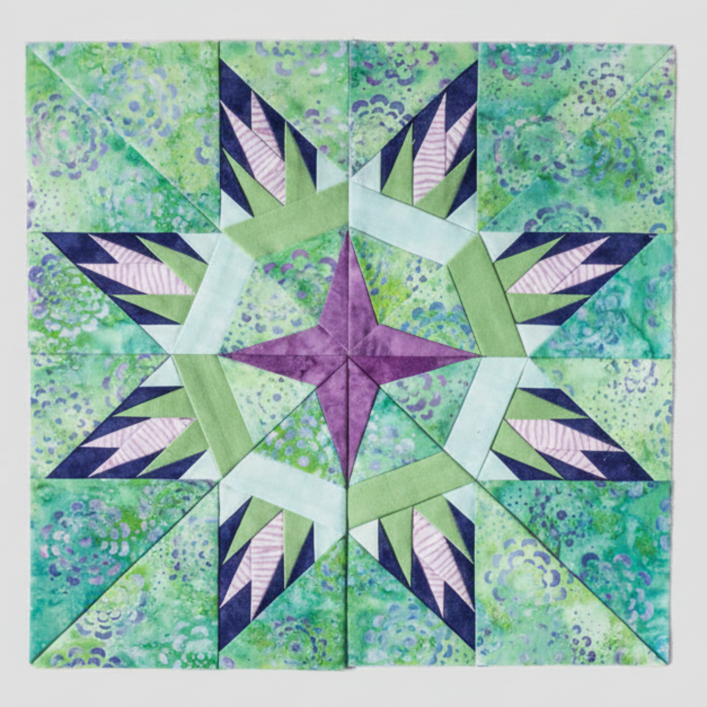 “Paper-pieced star quilt block in green and purple fabrics from 60 Fabulous Paper-Pieced Stars Second Edition”