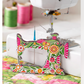 Superbloom sewing machine needle minder displayed next to a sewing machine on a quilted work surface