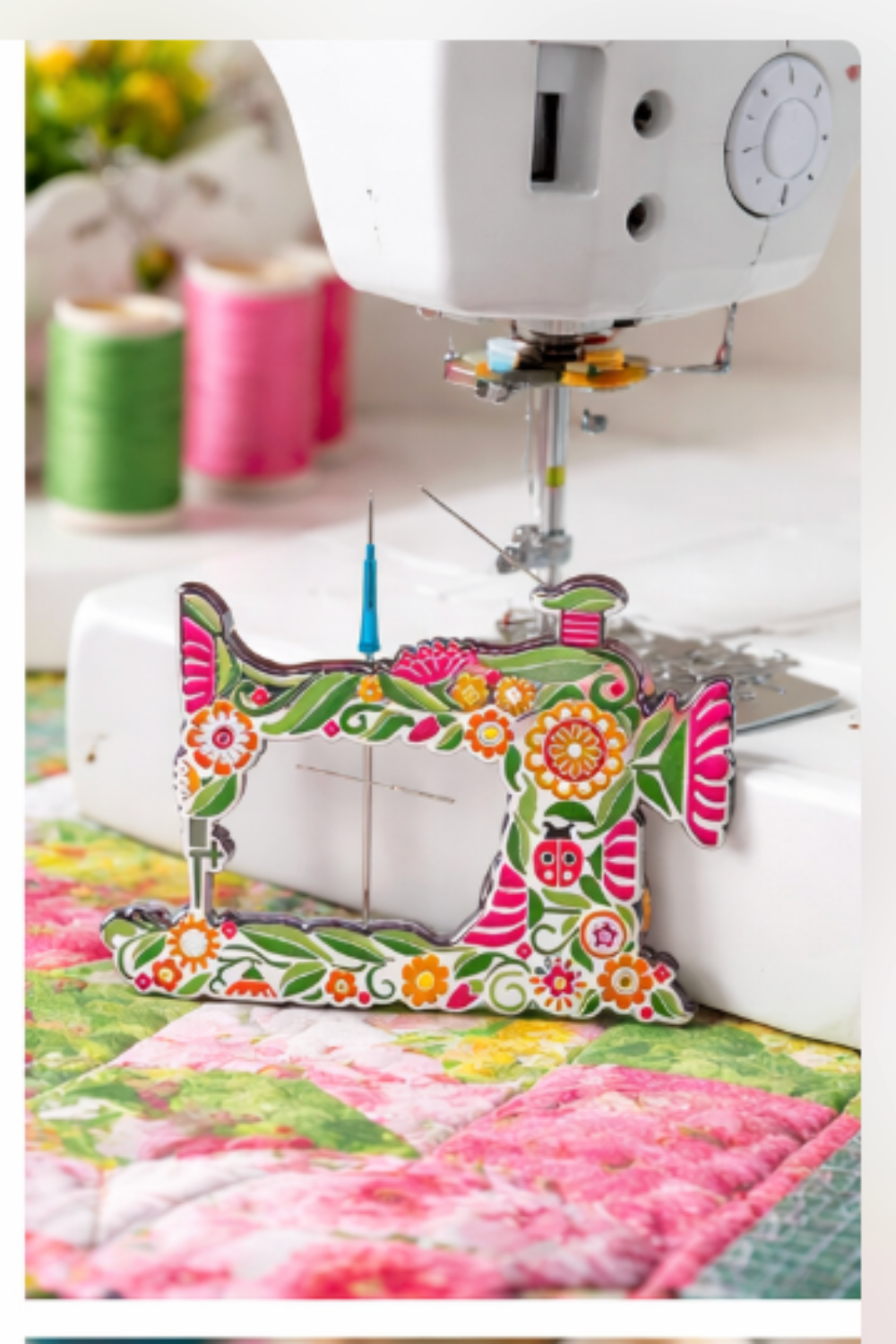 Superbloom sewing machine needle minder displayed next to a sewing machine on a quilted work surface