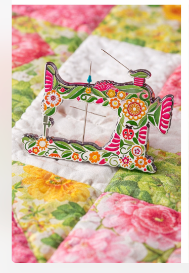 Decorative Superbloom sewing machine needle minder on a floral quilt, featuring Robin Pickens floral design