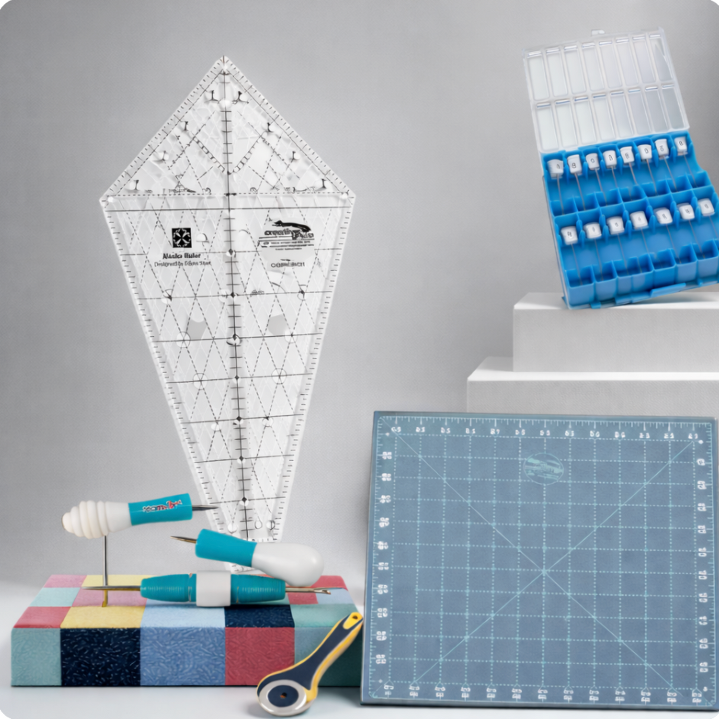 Creative Grids Alaska Quilt Ruler displayed with quilting tools including seam ripper, rotary cutter, and cutting mat