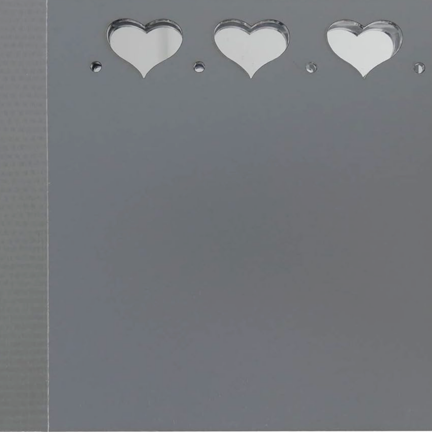 Close-up of Sue Daley fussy cutting mirror panel with heart cutouts and polished reflective surface