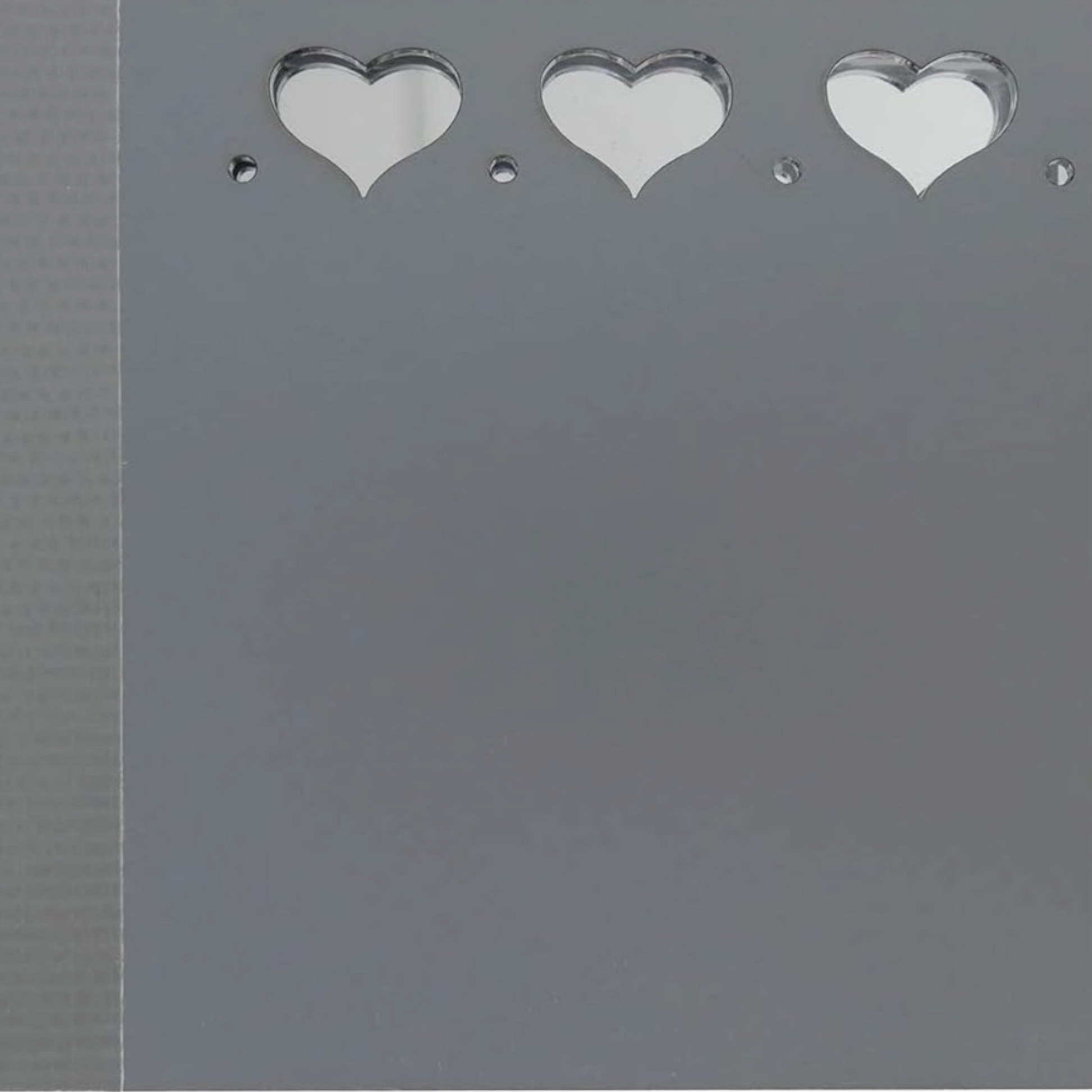 Close-up of Sue Daley fussy cutting mirror panel with heart cutouts and polished reflective surface