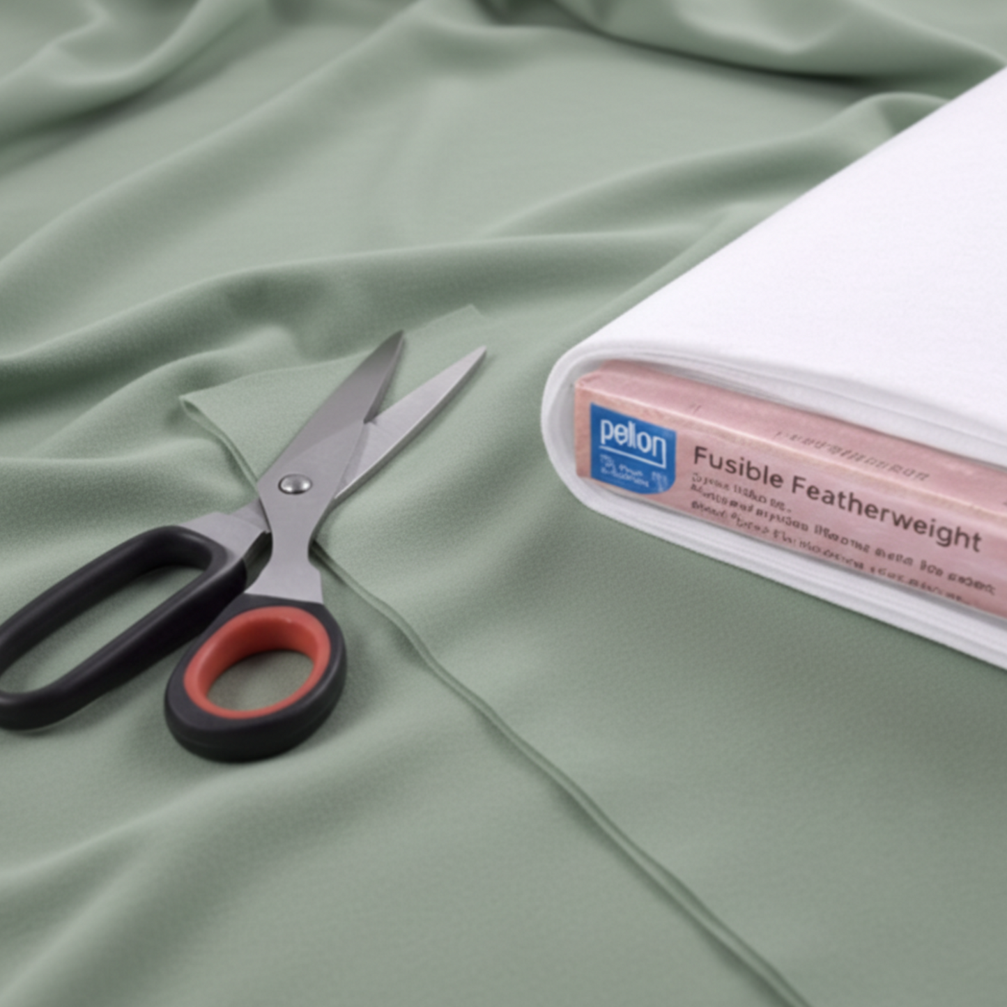 Scissors and a package of fusible interfacing on a fabric background