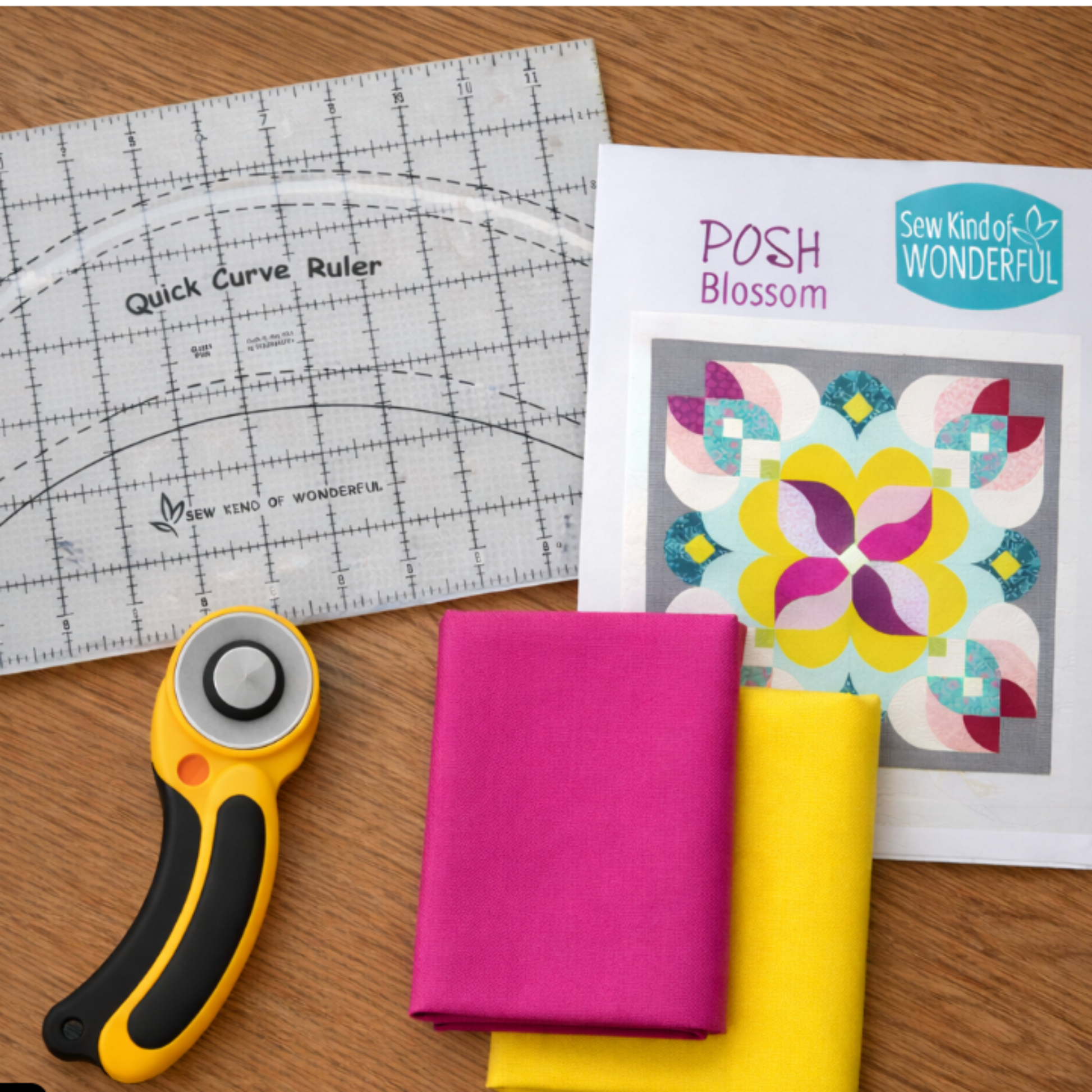 Quick Curve Ruler on a wooden table with rotary cutter and bright quilting fabrics, showing curved cutting setup.