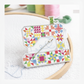Riley Blake sewing machine needle minder holding a hand sewing needle on embroidery fabric in hoop