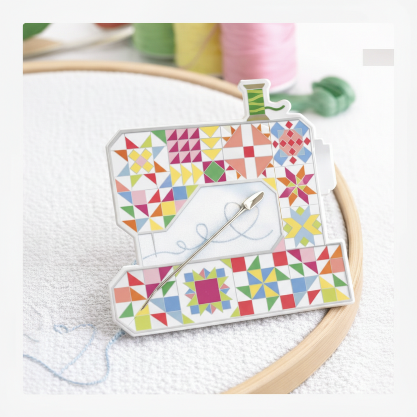 Riley Blake sewing machine needle minder holding a hand sewing needle on embroidery fabric in hoop