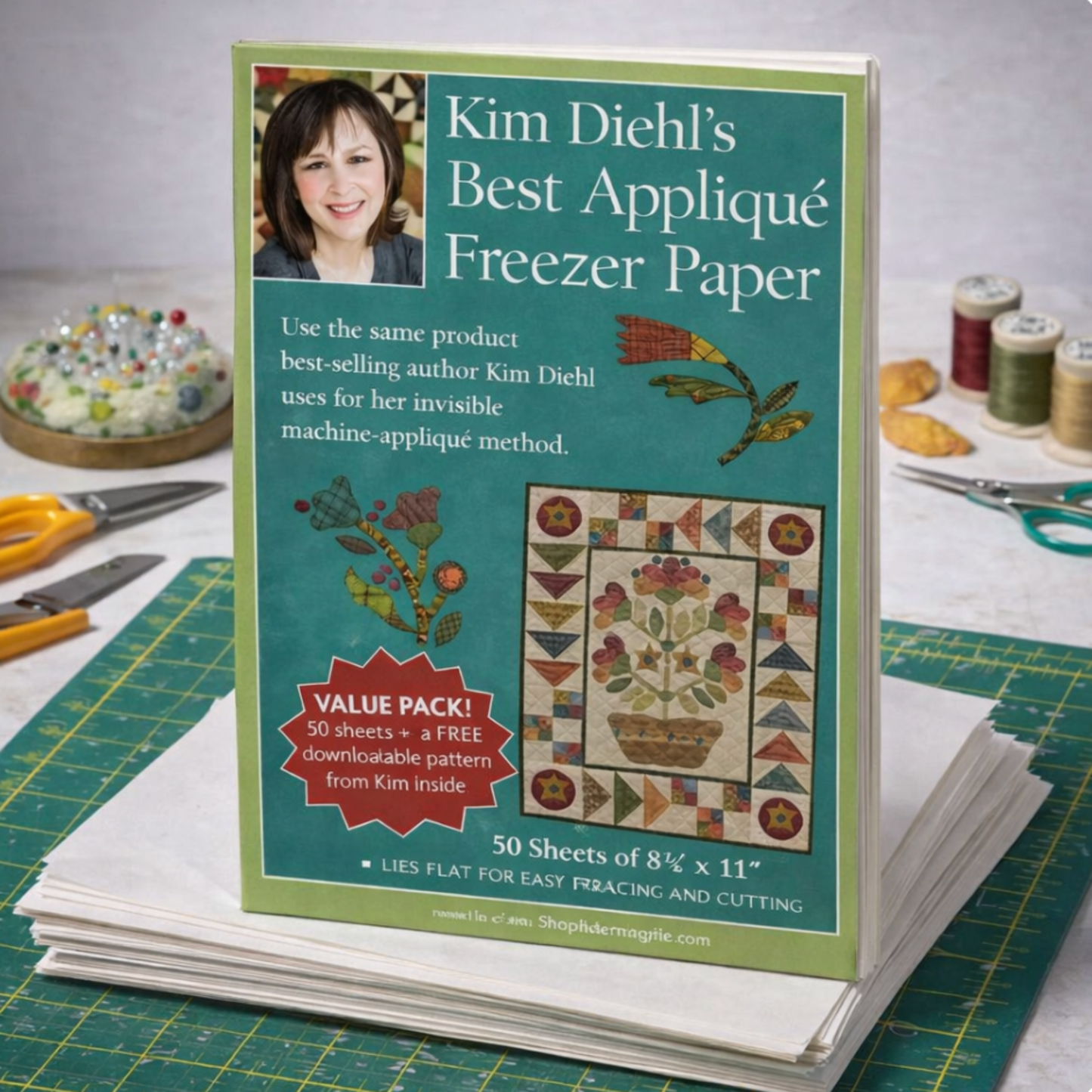 Booklet for Kim Diehl's Best Applique Freezer Paper on a quilting surface with tools and fabric.