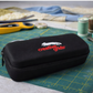 Black case with 'creative grids' logo on a cutting mat with sewing tools.