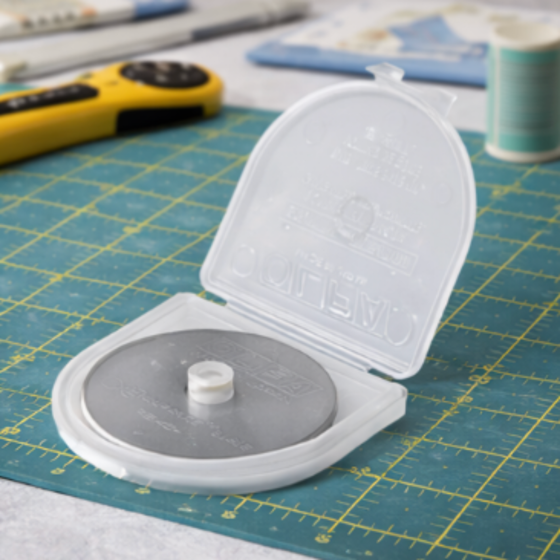 Circular cutting tool with open lid on a grid-patterned surface