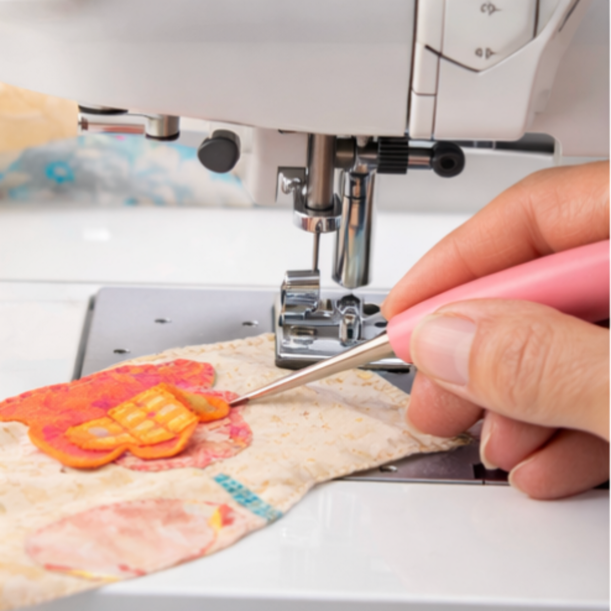 Using Laura Heine Stiletto to guide appliqué fabric under a sewing machine needle for safe stitching.