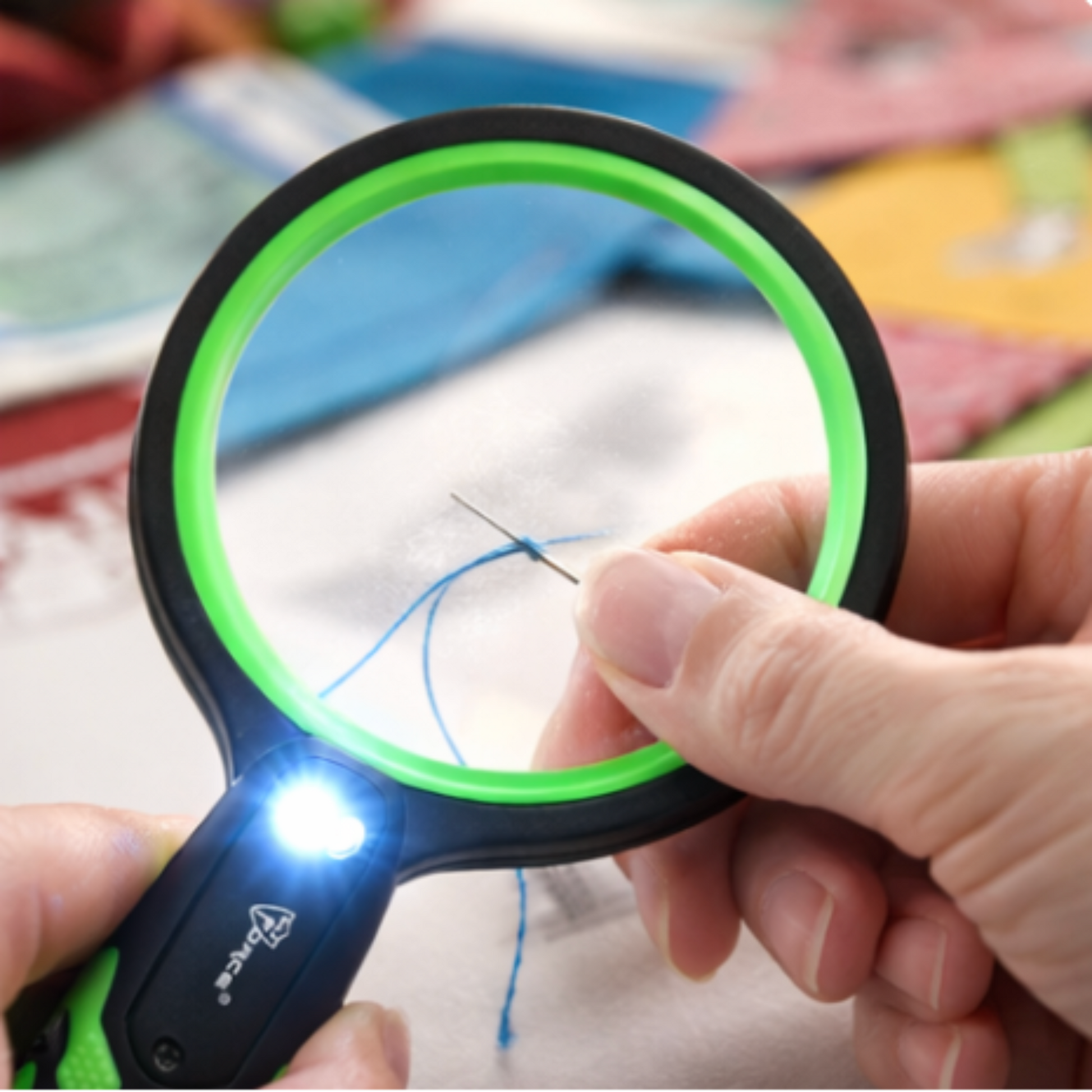 LED lighted magnifier helping thread a sewing needle for hand sewing and quilting