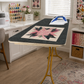 Large wool pressing mat on ironing table in bright sewing room with quilt block and iron