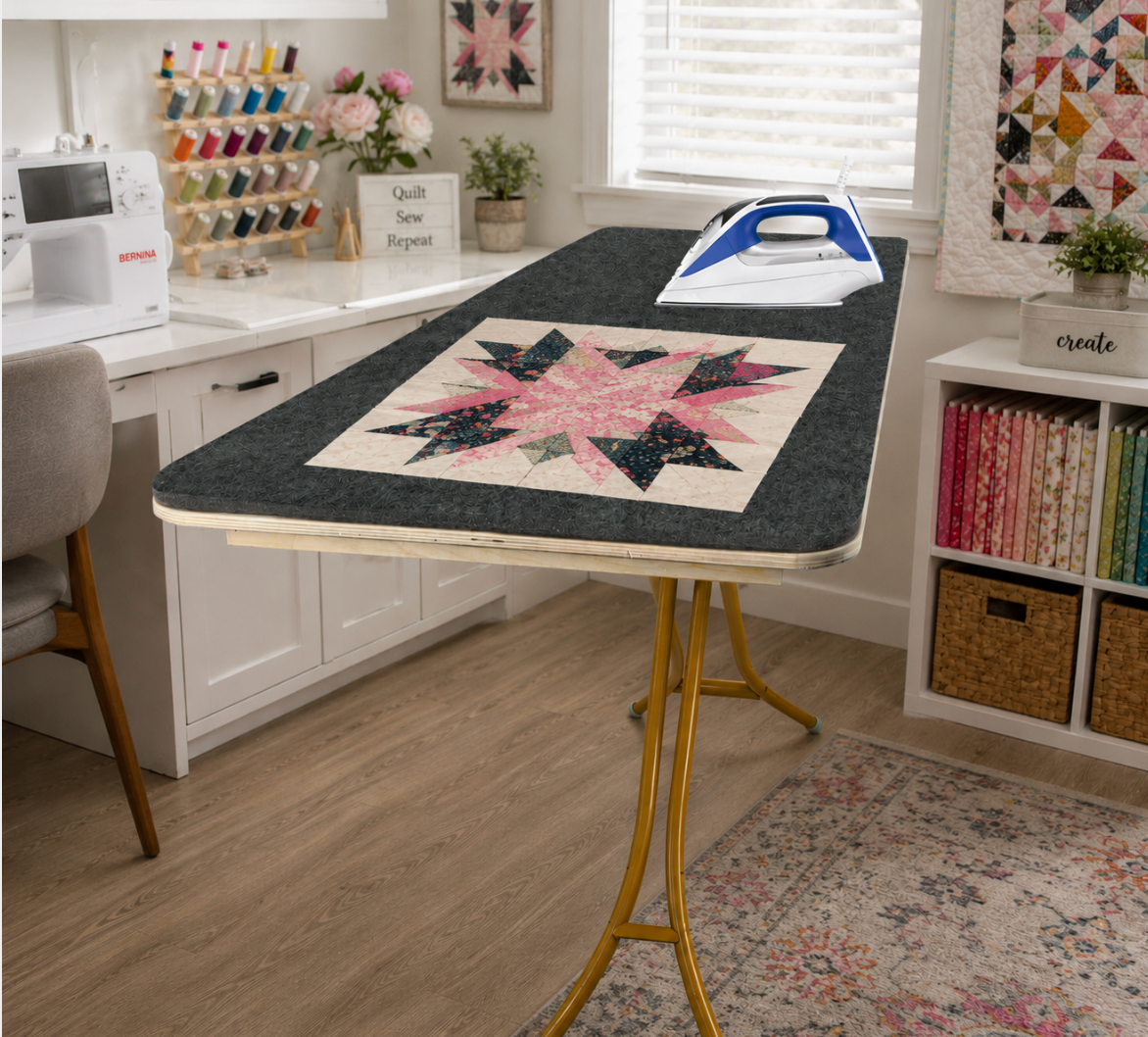Large wool pressing mat on ironing table in bright sewing room with quilt block and iron