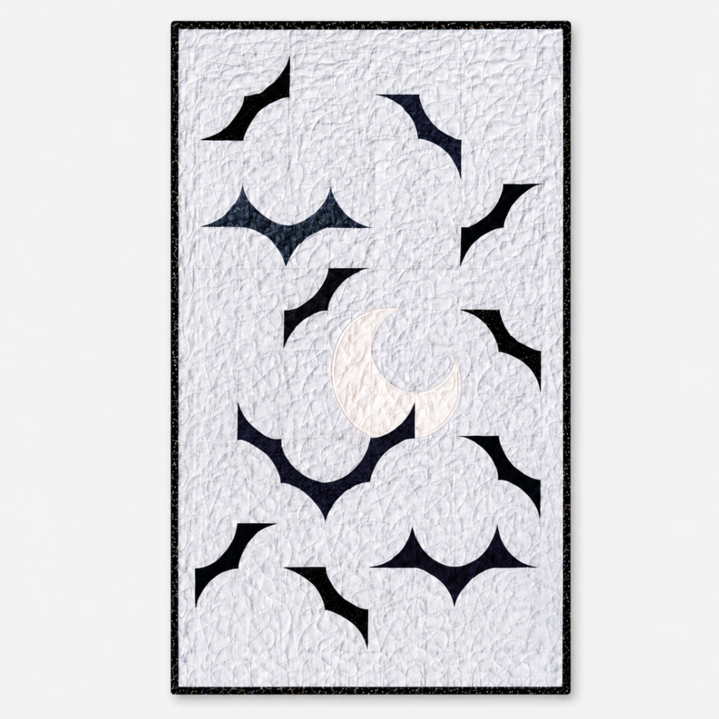 Handmade quilt with a light gray quilted background, dark bat shapes, and a cream crescent moon, finished with black binding.
