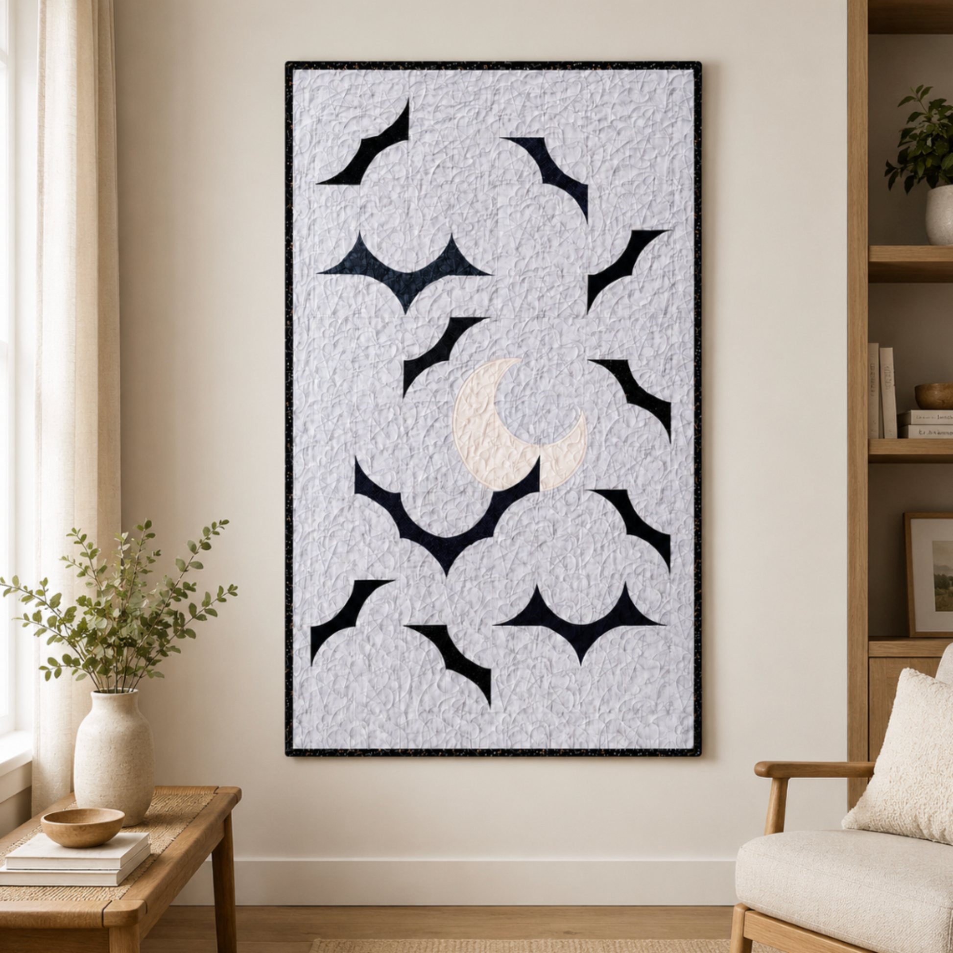 Modern moon and bat wall quilt hanging in a neutral living room above a wooden side table and beside a cozy cha