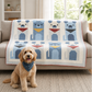 Handmade puppy quilt featuring twelve blue patchwork dog blocks draped over a sofa with a happy cream-colored dog sitting in front, creating a cozy pet-friendly living room scene.
