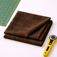 Interwoven Bark by Jason Yenter – lifestyle shot, fabric partially folded with rotary cutter, corner of cutting mat visible, light grey base