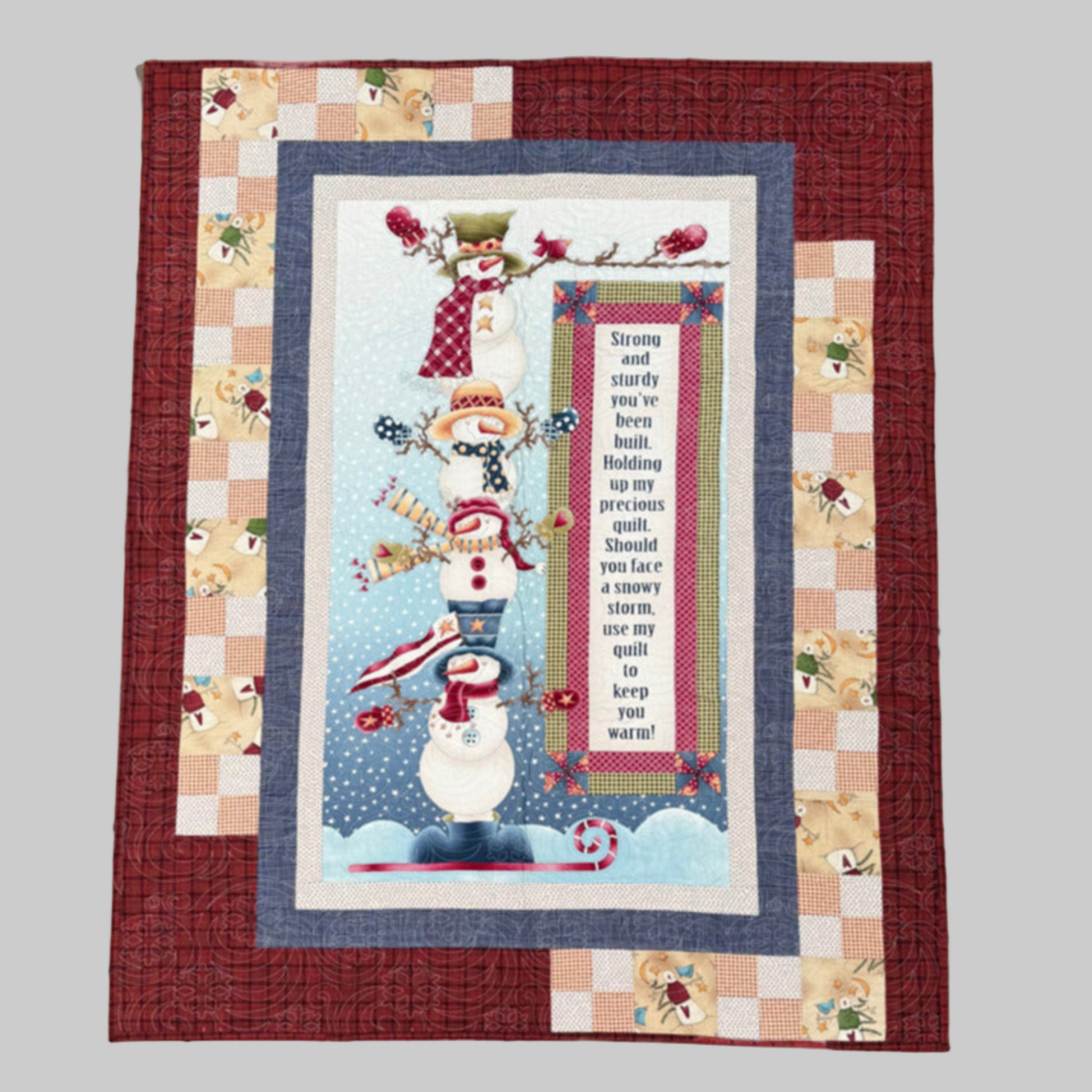 Quilt with a snowman design and text on a checkered border