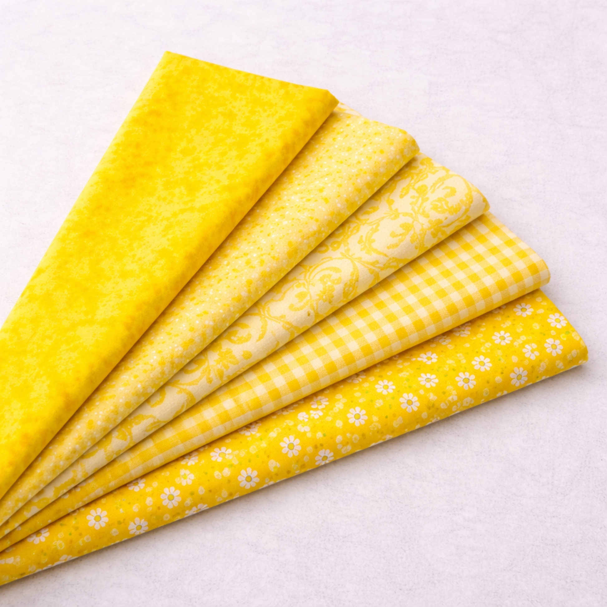 Expressions Batiks Hand-Dyes quilting cotton fabrics including Bumblebee – 5 coordinating fabrics in complementary warm and bright tones slightly fanned on light grey background