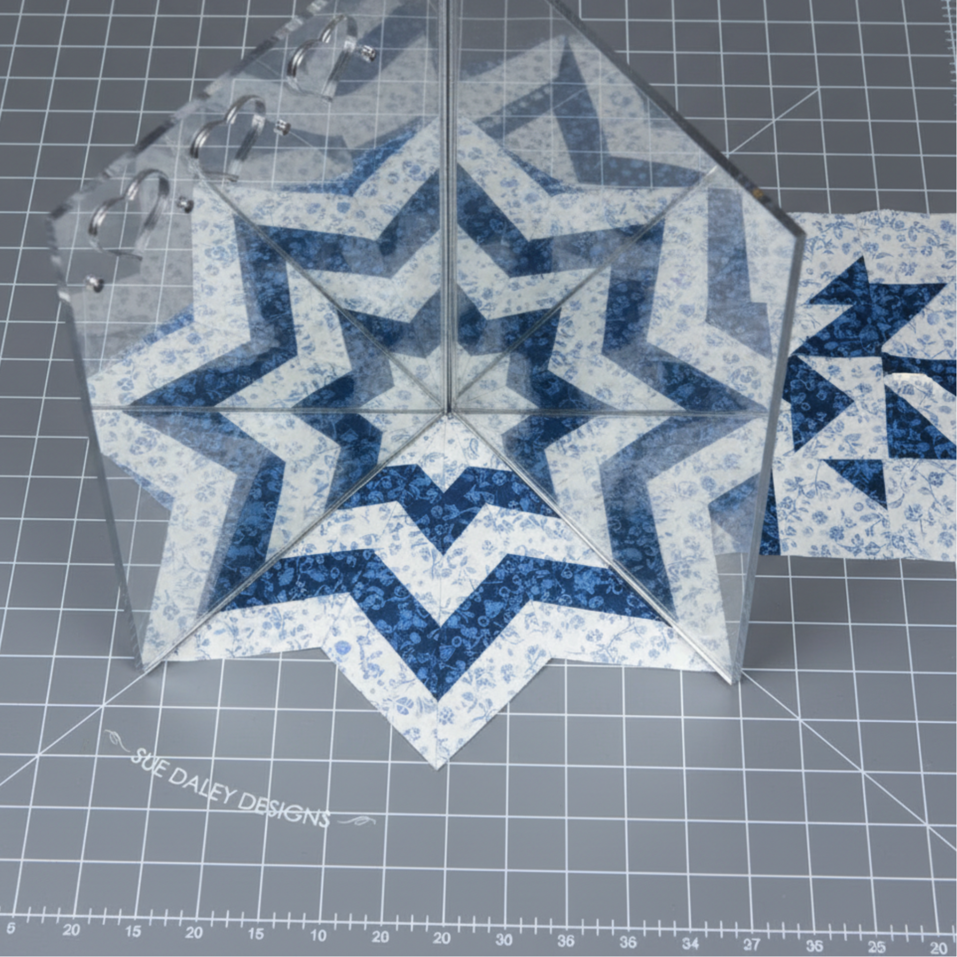 Sue Daley fussy cutting mirror demonstrating kaleidoscope fabric symmetry for quilting and English paper piecing