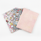 Alice Multi Characters, Alice Multi Teacups, and coordinating blush pink lattice quilting cotton fabrics by Jason Yenter for In The Beginning Fabrics shown in a three-fabric fan – whimsical Alice in Wonderland character scatter print, Mad Hatter teacup scatter print, and soft blush pink tonal geometric blender, 100% cotton, 3 yard cuts