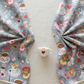 Alice Multi Teacups and Alice Multi Characters quilting cotton fabrics by Jason Yenter for In The Beginning Fabrics shown together – whimsical Mad Hatter tea party teacups and Alice in Wonderland character scatter prints on soft grey, perfect for children's quilts and novelty projects, 100% cotton, 3 yard cut
