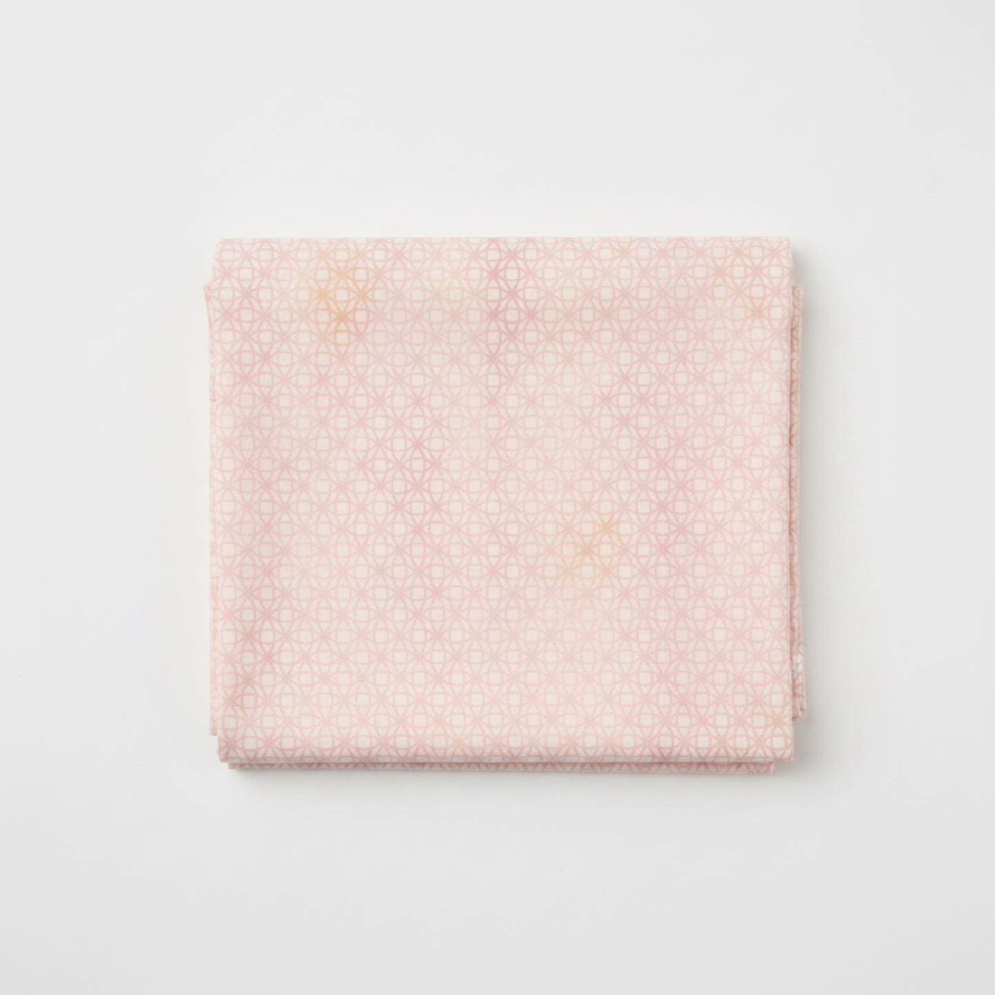 Allure Peach Lattice quilting cotton fabric folded to show soft tonal geometric lattice – interlocking star and diamond shapes in blush pink, peach, and cream with luminous watercolor wash effect by Jason Yenter for In The Beginning Fabrics, 100% cotton, 3 yard cut