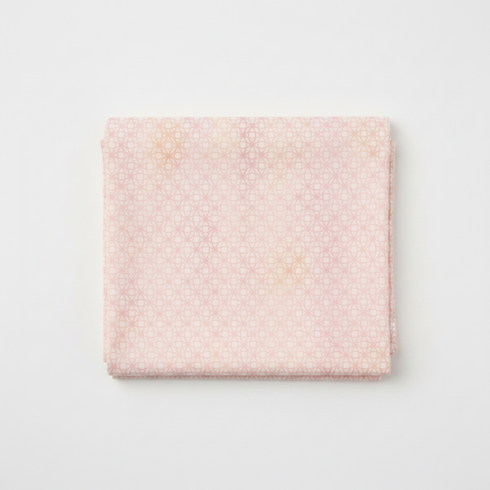 Allure Peach Lattice quilting cotton fabric folded to show soft tonal geometric lattice – interlocking star and diamond shapes in blush pink, peach, and cream with luminous watercolor wash effect by Jason Yenter for In The Beginning Fabrics, 100% cotton, 3 yard cut