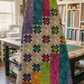 Interwoven Pink fabric by Jason Yenter for In The Beginning Fabrics in a finished Aurora Nights quilt draped on a quilt rack — vibrant magenta-pink crosshatch tonal strip coordinated with Interwoven colorways in teal, plum, tomato, pewter, and slate, with colorful eight-pointed star blocks on a light background. Quilts shown for inspiration feature the Aurora Nights Quilt Pattern (BTBQ142) by Bound to Be Quilting — available at IraRobi Quilts.