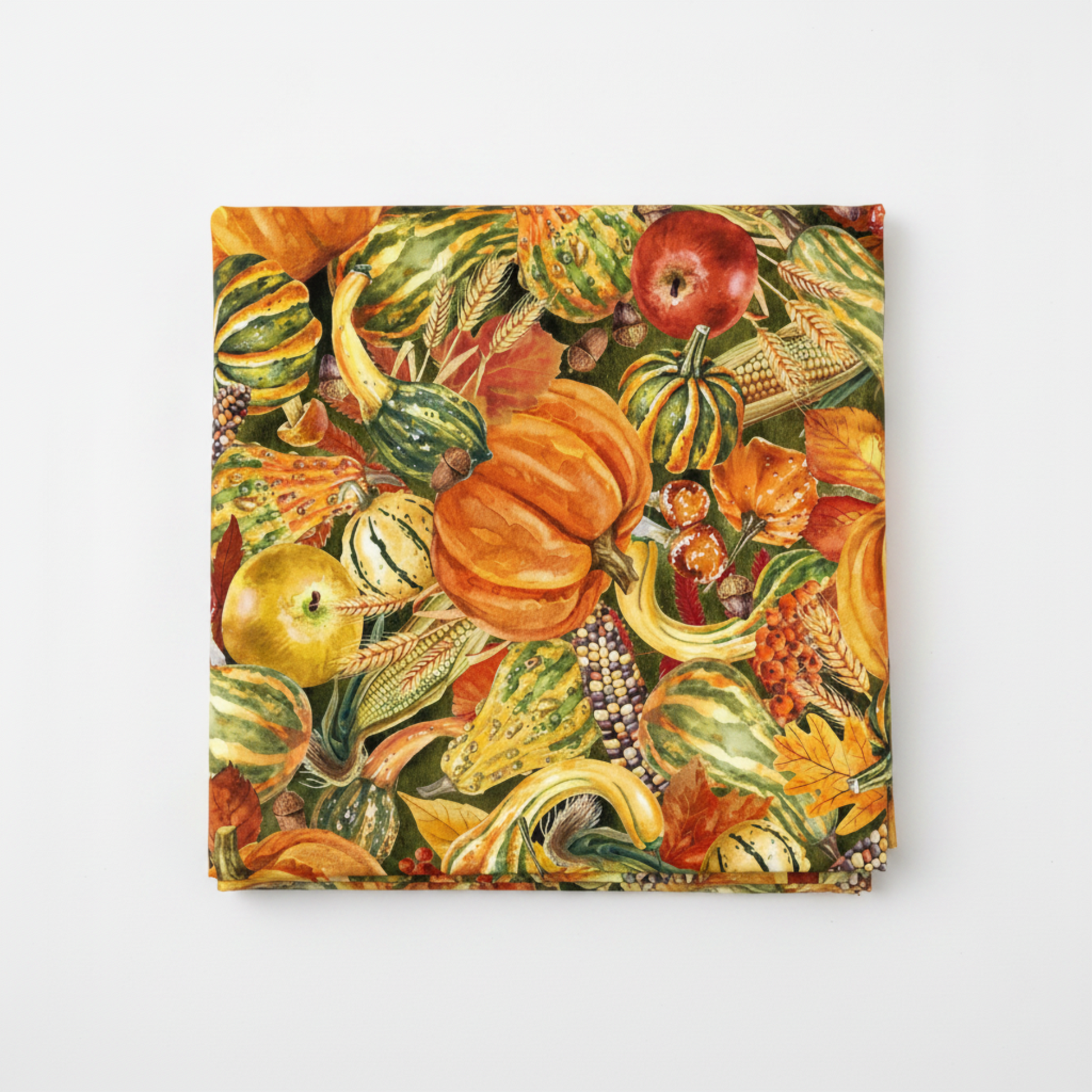 Autumn Celebration Multi Vegetables quilting cotton — folded fat quarter on a white surface showing the lush allover harvest print with orange pumpkins, striped gourds, Indian corn, apples, acorns, wheat, red berries, and fall oak leaves in deep orange, amber, green, and rust on dark olive. 100% cotton, 43–44" wide.