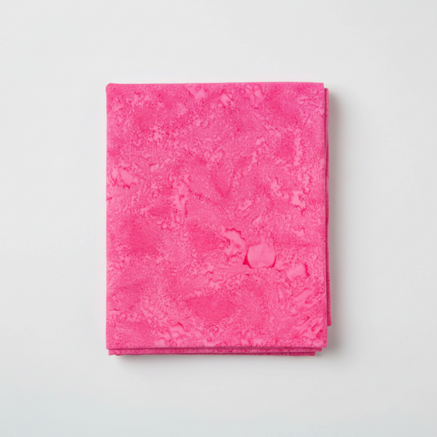 Expressions Batiks Hand-Dyes Begonia quilting cotton fabric by Riley Blake Designs folded into a neat square showing pure saturated hot pink hand-dyed batik with subtle light-to-dark tonal shifts and organic painterly mottled texture – a vibrant single-hue tonal blender, 100% cotton batik, 43–44" wide