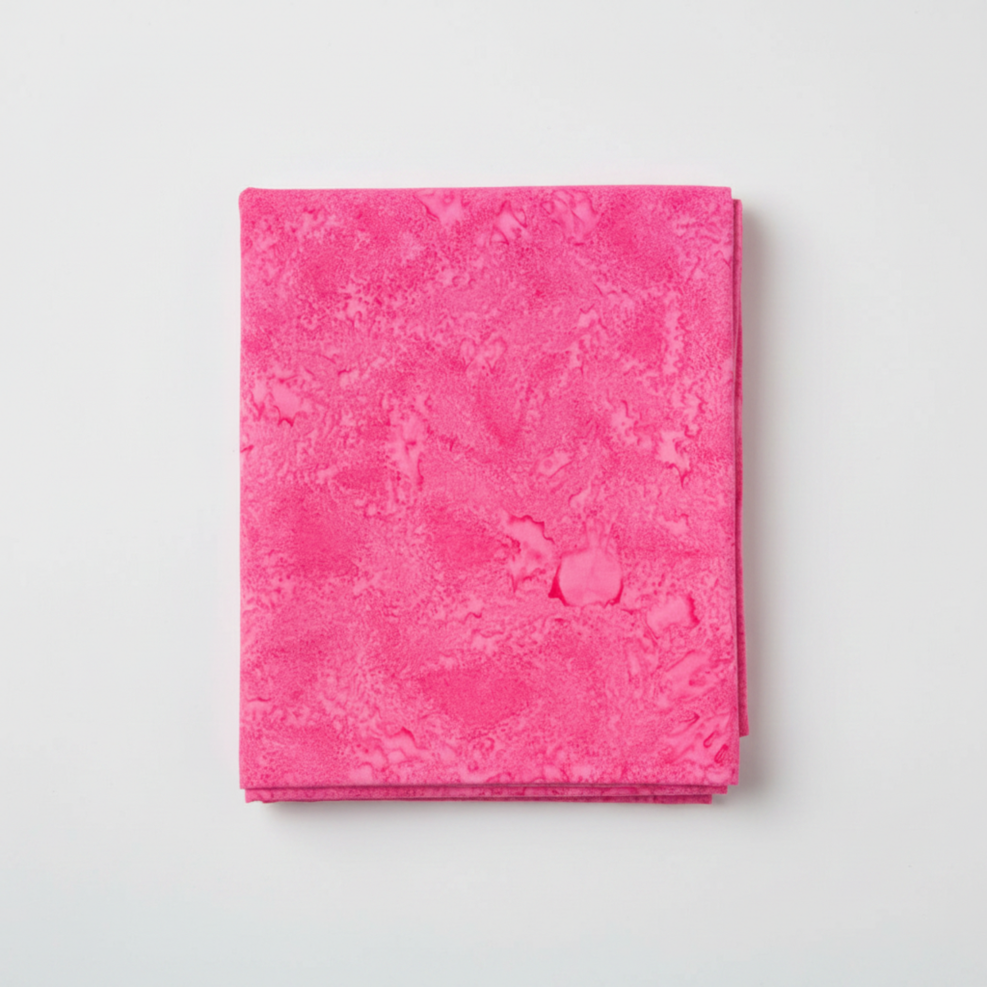 Expressions Batiks Hand-Dyes Begonia quilting cotton fabric by Riley Blake Designs folded into a neat square showing pure saturated hot pink hand-dyed batik with subtle light-to-dark tonal shifts and organic painterly mottled texture – a vibrant single-hue tonal blender, 100% cotton batik, 43–44" wide
