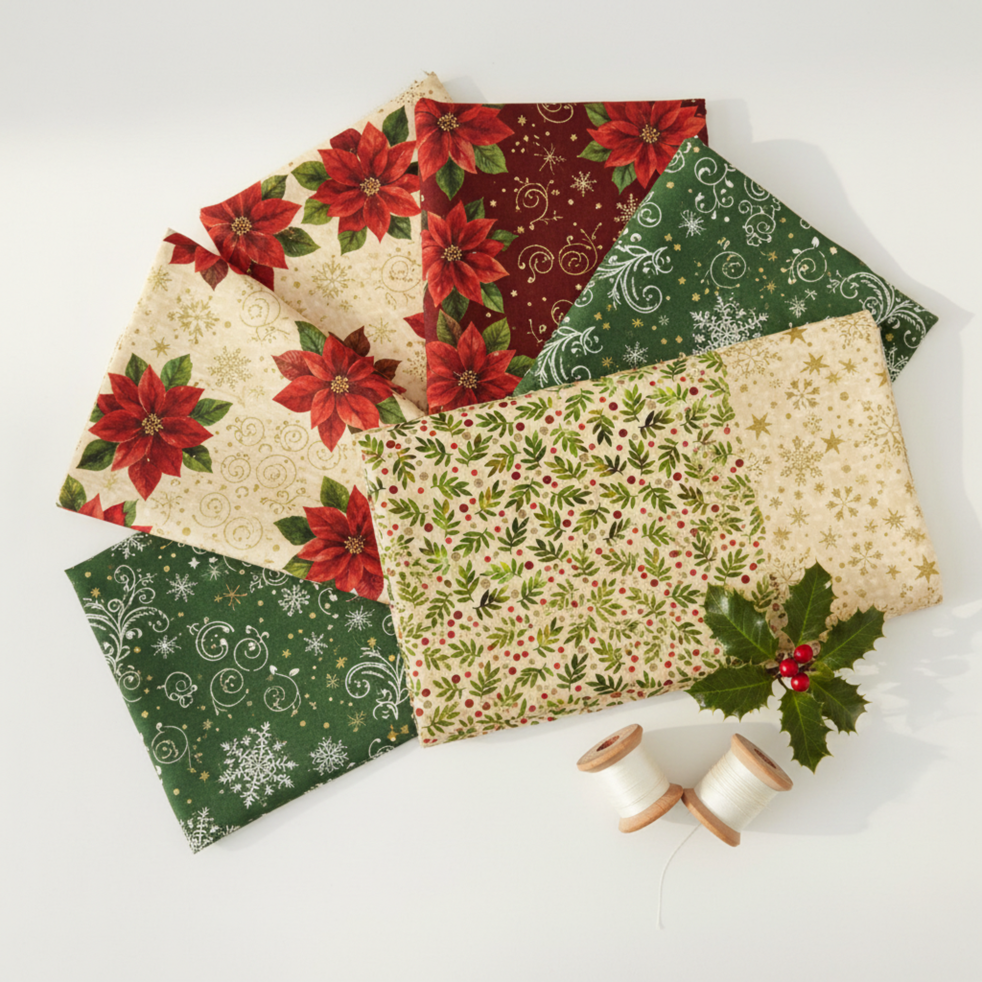 Winter Solstice II Beige Twigs Metallic Fabric by Jason Yenter for In The Beginning Fabrics — shown with coordinating quilting cottons fanned flat, with cream and gold metallic thread spools and a holly sprig. Coordinating fabrics and quilt patterns are available at IraRobi Quilts.