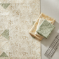 Modern quilt project flat lay featuring Expressions Batiks Breathe Ecru by Riley Blake Designs as background fabric with coordinating soft sage green and warm cream tonal batik fabrics in the pieced blocks, with folded fabric and quilting ruler – 100% cotton batik