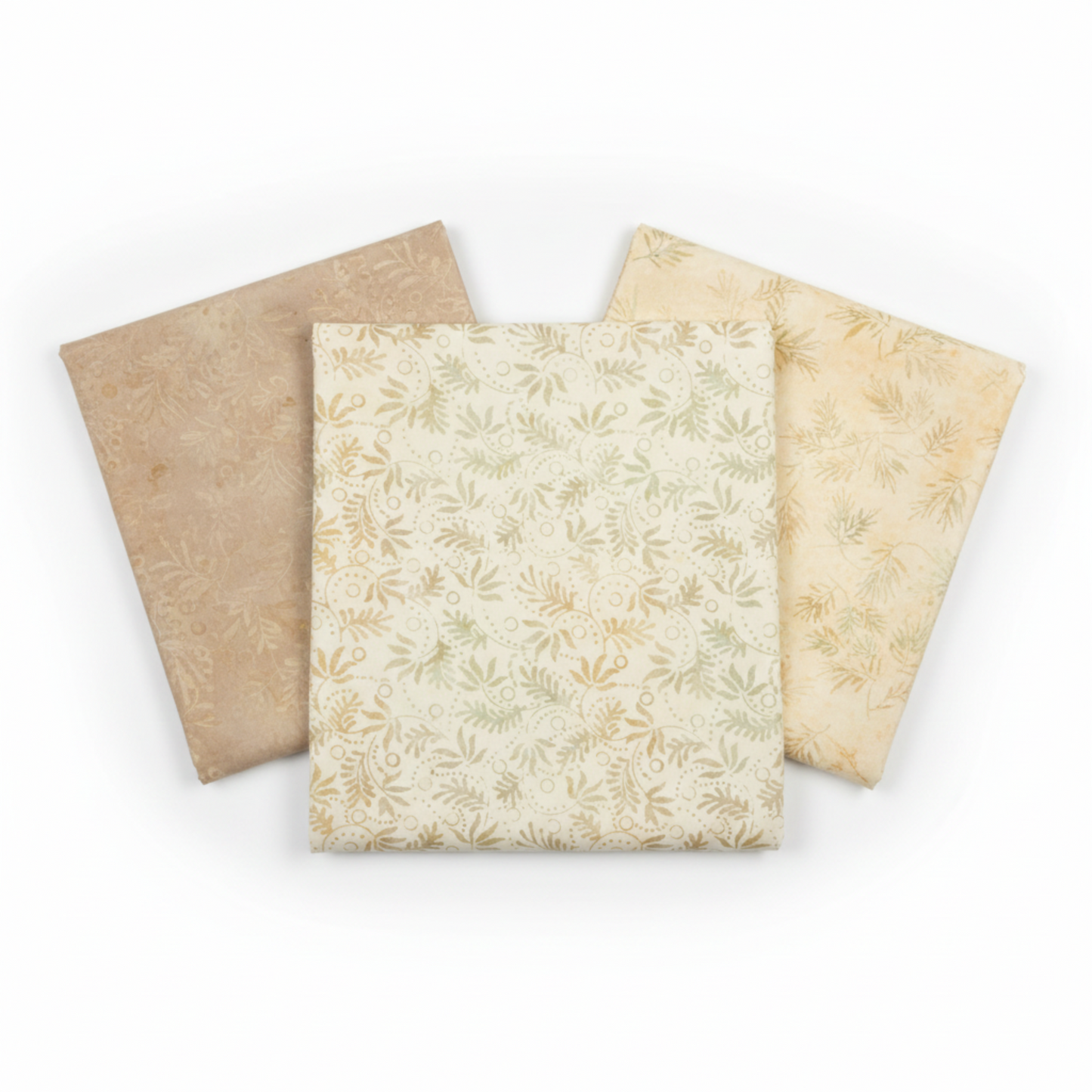 Three coordinating tonal batik fabrics in a fan arrangement featuring Expressions Batiks Breathe Laurel by Riley Blake Designs in cream and ivory with sage green leaf sprigs, flanked by warm taupe and soft golden-cream tonal batiks – 100% cotton