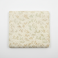 Expressions Batiks Breathe Laurel quilting cotton fabric by Riley Blake Designs folded into a neat square showing cream and ivory tonal batik with feathery fronds, dotted swirl outlines, and leaf sprigs in soft sage green and warm taupe – a sophisticated botanical blender, 100% cotton batik, 43–44" wide
