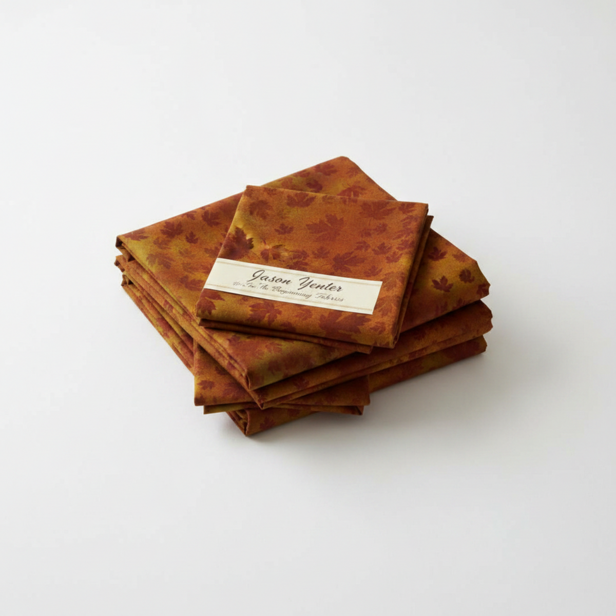 Autumn Celebration Brown Maple Leaves tonal blender quilting cotton by Jason Yenter for In The Beginning Fabrics — tossed dark burgundy-maroon maple leaf silhouettes at varying sizes on a mottled burnt amber, olive gold, and deep rust watercolor ground. 100% cotton, 43–44" wide.