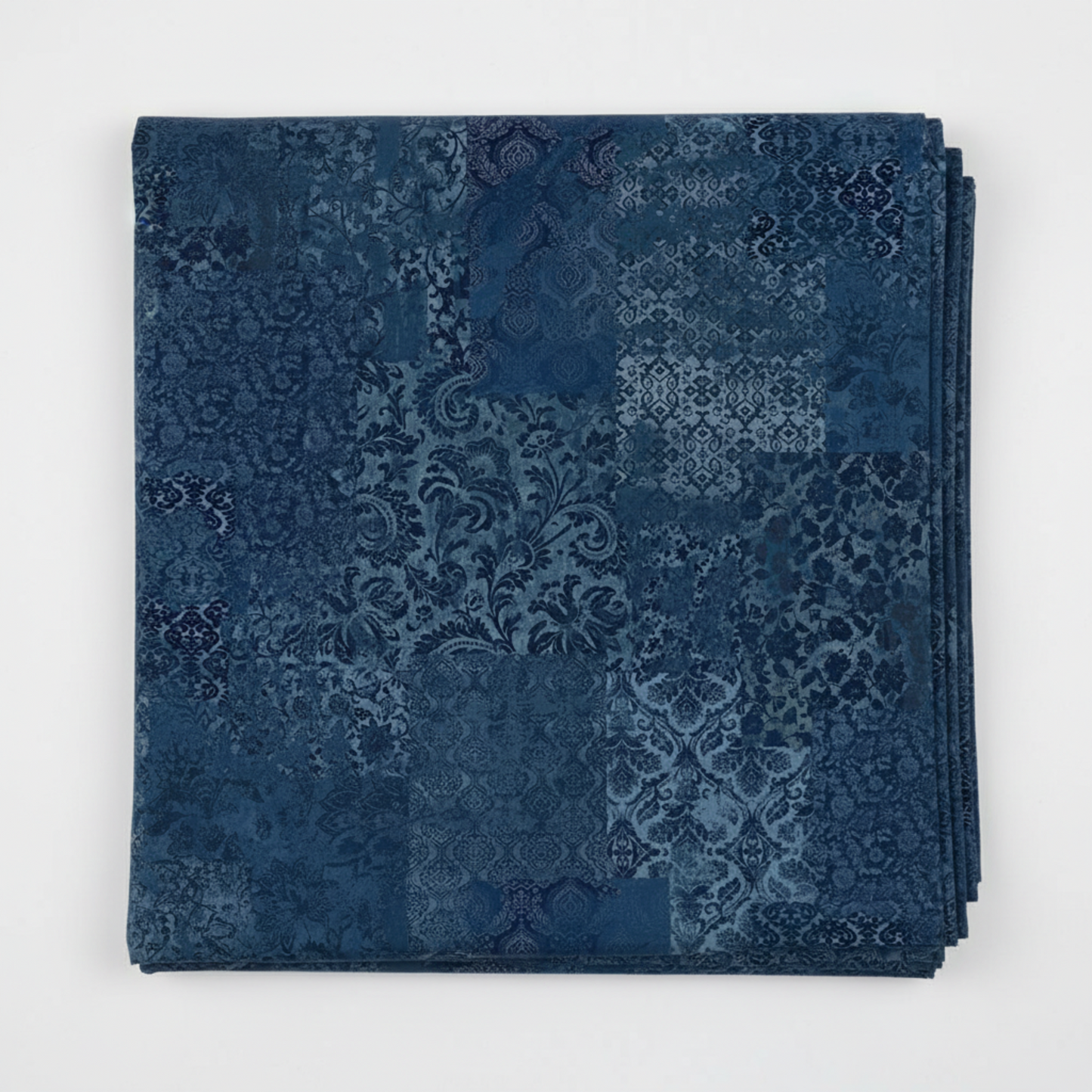 Carpet Bag Romance Blue Brocade quilting cotton fabric folded to show tonal patchwork of damask, brocade, scrollwork, and medallion motifs – deep navy and steel blue faded-carpet collage by Jason Yenter for In The Beginning Fabrics, 100% cotton, 3 yard cut