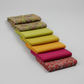 What If Good Vibes Gold/Multi fabric in cascading staircase with Interwoven Citron, Marigold, Magenta and Radio Star Red/Multi — color palette by Paula Nadelstern for Benartex