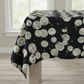 Celestial News Dropping Onyx cotton fabric by Zen Chic for Moda draped over a table, showing large cream newspaper circles and gold dots on black