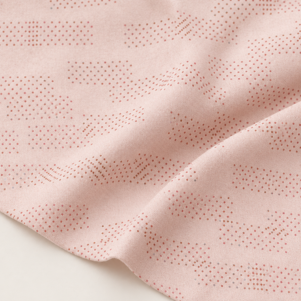 Celestial Washi Rose Quartz fabric arranged in soft folds, showing its pale blush ground and small dotted motifs.