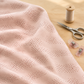 Celestial Washi Rose Quartz fabric draped across a sewing table beside thread, scissors, and fabric clips.