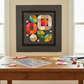 Creative Grids Non-Slip Circle Savvy Ruler on a sewing table with fabric remnants and thread bobbins, with a finished modern circle quilt in charcoal, pink, orange, teal, and mustard displayed on the wall behind. Quilts shown for inspiration feature the Mod Flower Box Quilt Pattern by Robin Pickens