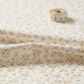 Close-up of Garden of Dreams II Gold Buds fabric showing delicate golden bud motifs and cotton texture