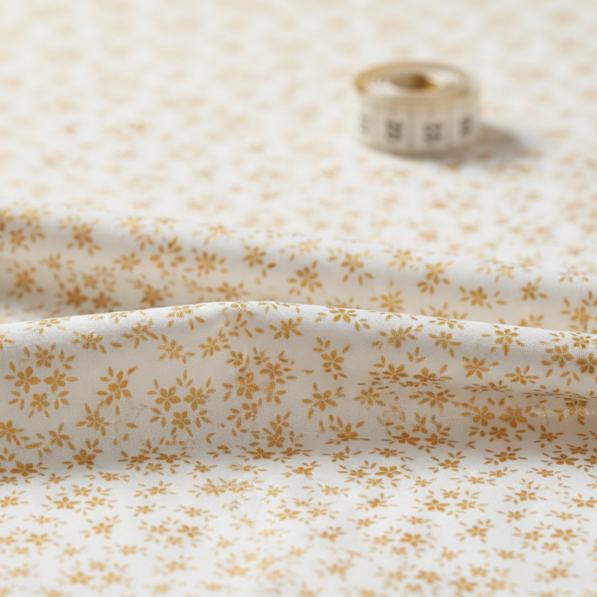 Close-up of Garden of Dreams II Gold Buds fabric showing delicate golden bud motifs and cotton texture